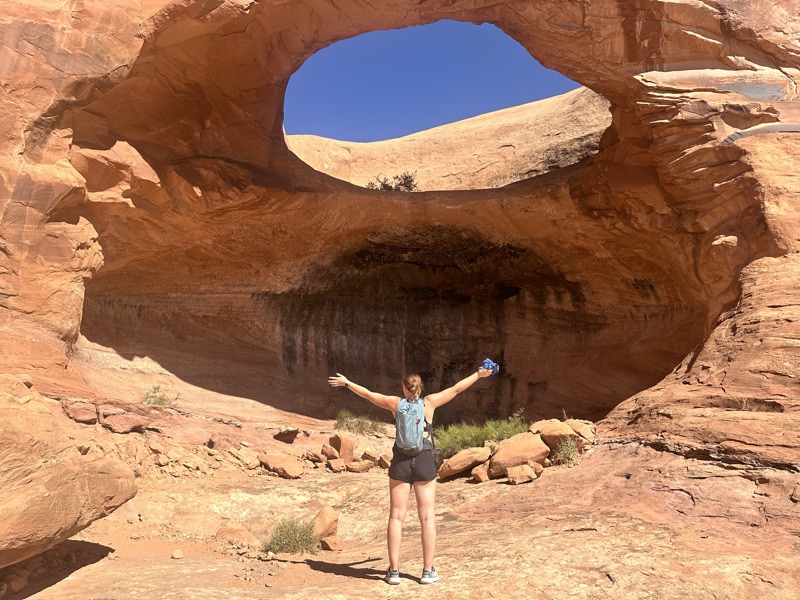 Standing beneath a sandstone arch in the Moab desert